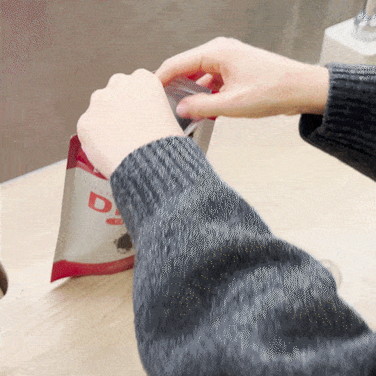 A package of Lulutox Detox Tea next to a freshly brewed cup of tea on a clean white kitchen counter