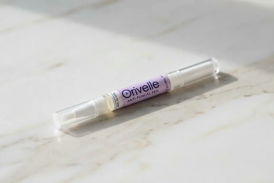 The Orivelle anti-fungal nail care pen with its precise applicator tip on a marble surface